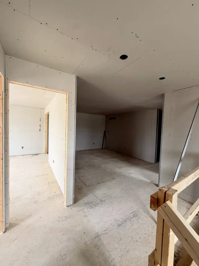 An upper floor in a new Union West home with open doorways and a stair railing, walls and ceilings hung.